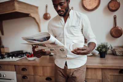 Midsection of man holding table at home