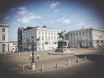 Buildings in city against cloudy sky