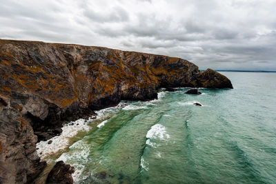 Rock formations by sea against sky