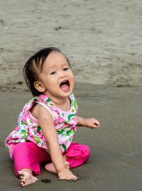 Portrait of baby girl playing with sand at beach