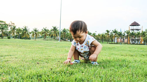 Full length of girl crouching on grass