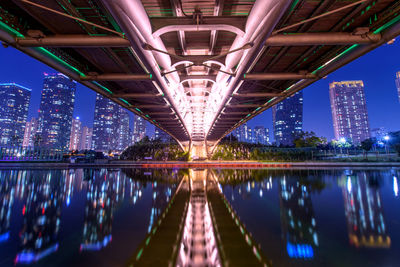 Illuminated bridge in city against clear sky at night