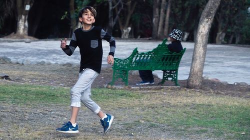 Full length of happy boy running in park