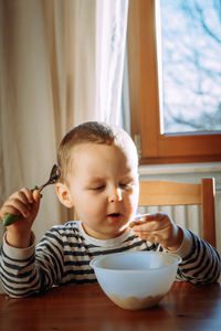 Portrait of cute baby boy sitting on the table at home