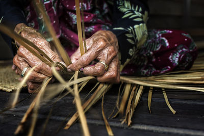 Midsection of senior woman making leaves craft product