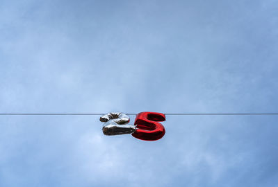 Low angle view of red flags hanging against sky