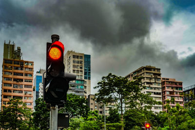 Low angle view of road sign against cloudy sky