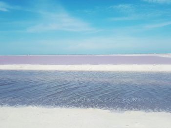 Scenic view of beach against blue sky