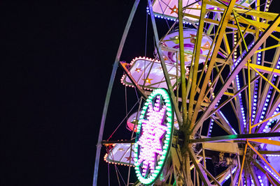 Low angle view of illuminated ferris wheel against sky at night