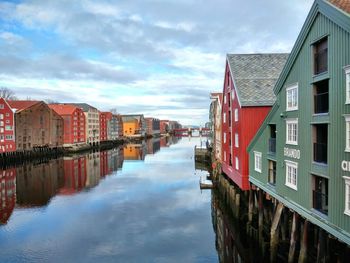 Reflection of houses in water against sky