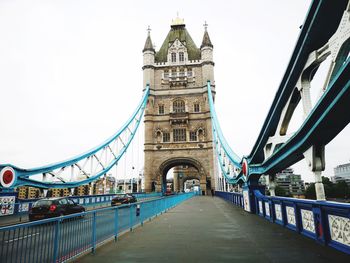 View of footbridge in city against sky