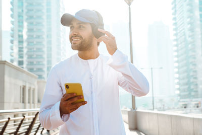 Young man using mobile phone in city