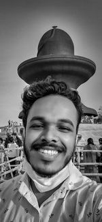 Portrait of smiling young man against sky