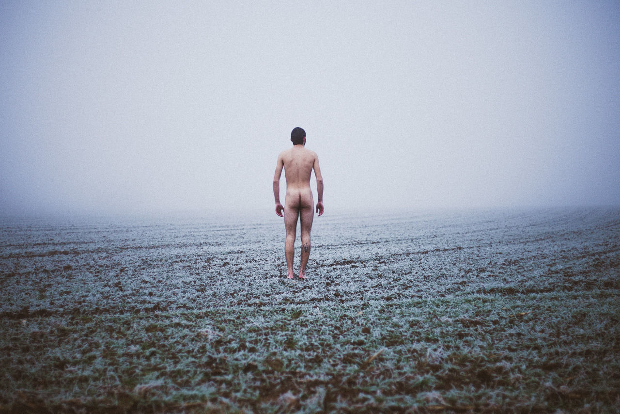 REAR VIEW OF MAN WALKING ON BEACH