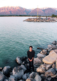 Man standing on rocks by sea