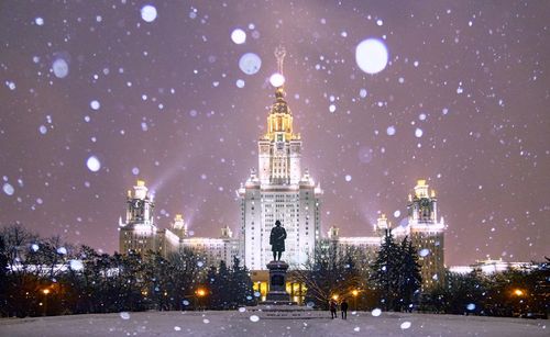 Heavy evening snowfall in nicely illuminated campus of famous russian university