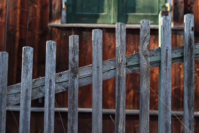 Close-up of wooden fence against barn