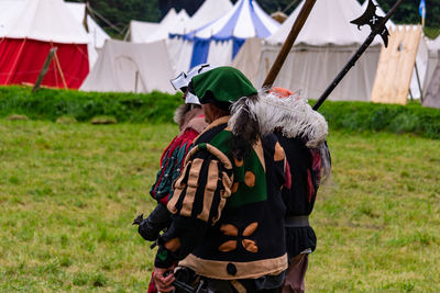 People in traditional clothes standing on field