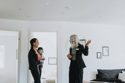 Young woman standing against wall at home