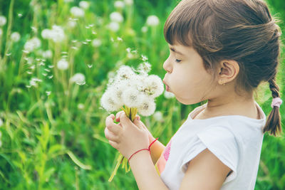 Close-up of girl blowing dandelion