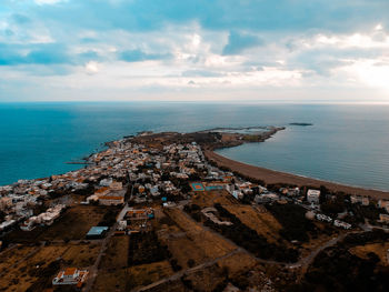 High angle view of townscape by sea against sky