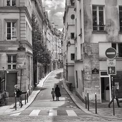 People walking on road amidst buildings in city