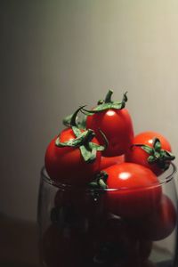 Close-up of tomatoes in glass container on table