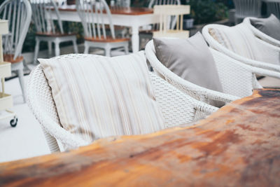 Close-up of white chairs by table at restaurant