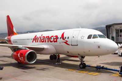 Airplane on airport runway against sky