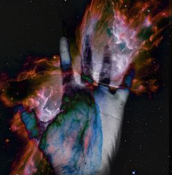 Close-up of human hand against multi colored sky