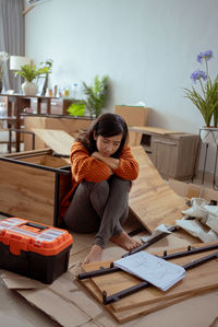 Portrait of young woman using digital tablet while sitting on table