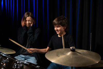 Smiling boy playing drum at stage