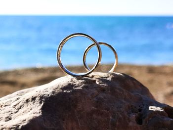 Close-up of wedding rings on the beach