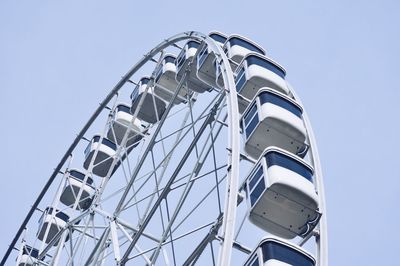 Low angle view of ferris wheel against clear blue sky