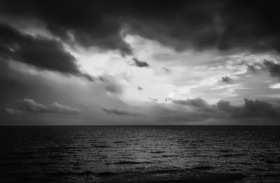 Scenic view of sea against storm clouds