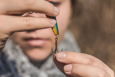 Close-up of woman holding blue fishing bait