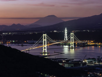 Illuminated bridge over river at night