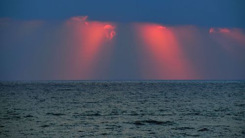 Scenic view of sea against rainbow in sky