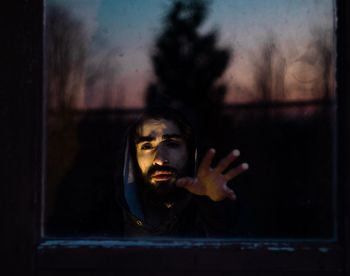 Portrait of man seen through glass window