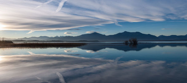 Scenic view of lake chiemsee by mountains against sky