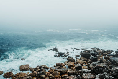 Scenic view of rocks in sea against sky