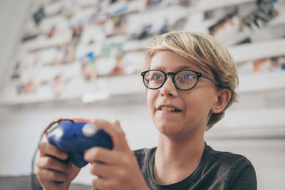 Portrait of smiling boy holding eyeglasses