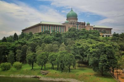 View of trees and building against sky