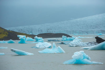 View of ice floating on sea against sky