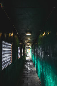 Empty walkway in illuminated tunnel