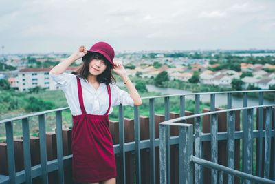 Portrait of woman in hat standing against sky