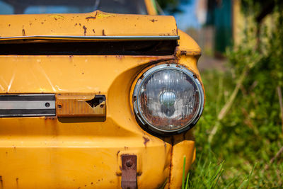 Old yellow wrecked car in vintage style. abandoned rusty yellow car. 