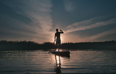 Silhouette of a man with a paddle on a sup surfboard. theme of an active lifestyle