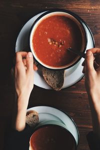 Cropped hands on woman with fresh soup on table