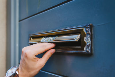 Close-up of hand holding metal door